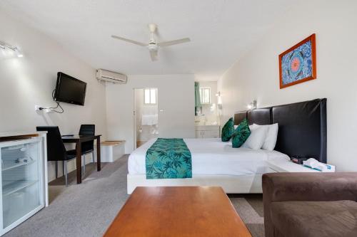 Habitación de hotel con cama y escritorio en Coffs Harbour Pacific Palms Motel, en Coffs Harbour