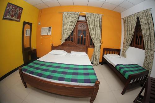 a bedroom with two beds and a window at Airport Tourist Hostel in Katunayake