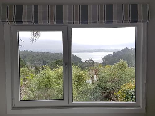 a window with a view of the ocean at Fernglen B&B in Auckland