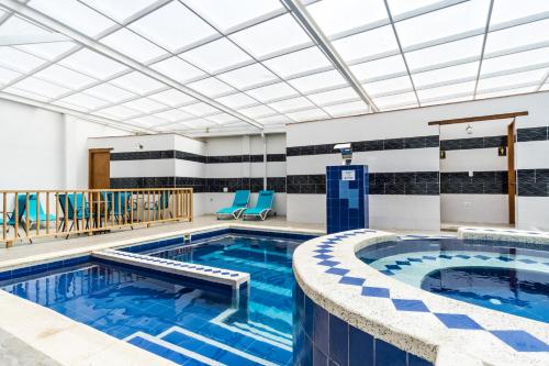 einen Pool in einem Hotelzimmer mit blauen Stühlen in der Unterkunft Hotel El Giro in Villa de Leyva