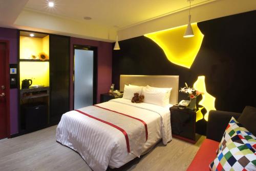 a bedroom with a large bed and a yellow wall at Cai-Lai Motel in Yangmei