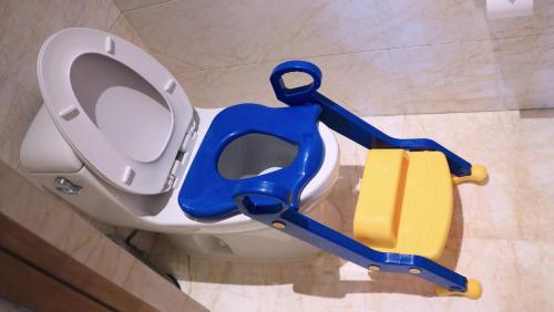a bathroom with a toilet with a blue and yellow apparatus at Wanda Vista Taiyuan in Taiyuan