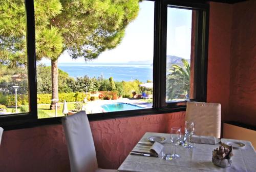 a table in a restaurant with a view of the ocean at Resort Le Picchiaie in Portoferraio