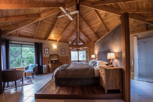 1 dormitorio con 1 cama y ventilador de techo en Cape Howe Cottages, en Lowlands