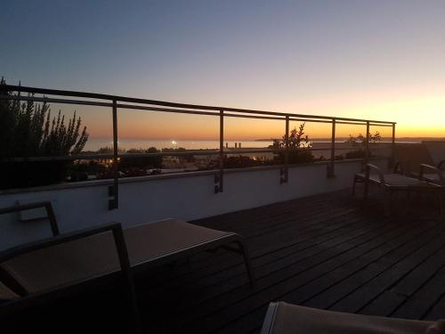 a balcony with a view of the ocean at sunset at Alvor Ria Apartment in Alvor