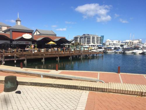 a marina with tables and chairs on a pier at Breakwater Short Stay in Mandurah