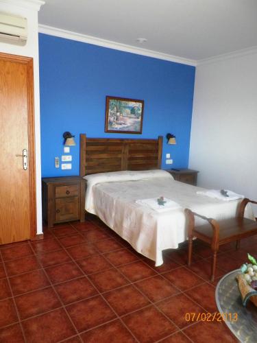 a bedroom with a large bed and a blue wall at Casa Francisco el de Siempre in El Palmar