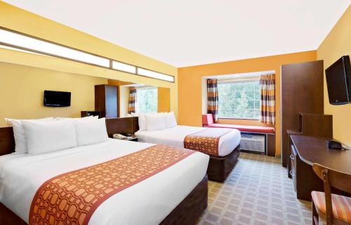 Habitación de hotel con 2 camas y escritorio en Microtel Inn & Suites by Wyndham Princeton, en Princeton