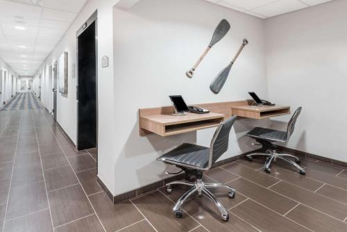 an office with two chairs and a desk and two paddles on the wall at Microtel Inn & Suites by Wyndham - Penn Yan in Penn Yan