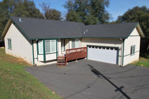 a small white garage with a bench in front of it at Big Tom's Cabin by Yosemite, lake and trails in Groveland