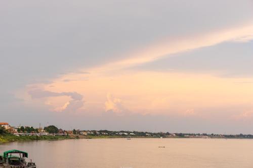 a rainbow in the sky over a river at Vieng Khong Hotel in Mukdahan