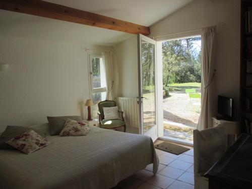 une chambre avec un lit et une porte coulissante en verre dans l'établissement La Tangana, à Rognes