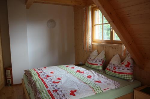 1 dormitorio con 1 cama en una cabaña de madera en Stillbacherhütte, en Mariahof
