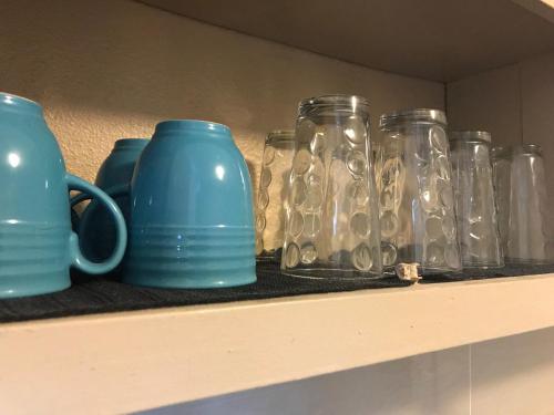 a shelf with several glass jars and a blue mug at 1 BEDROOM / 1 BATH . PRIVATE APT. FREE WIFI, INTERENT & PARKING in Sinajana