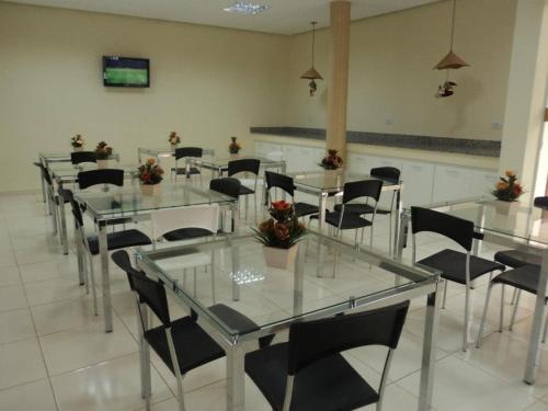 a dining room with glass tables and black chairs at Hotel Cambui in Seabra