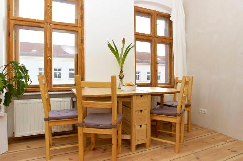 un tavolo e delle sedie in una stanza con finestre di Berlin Apartments Mitte a Berlino