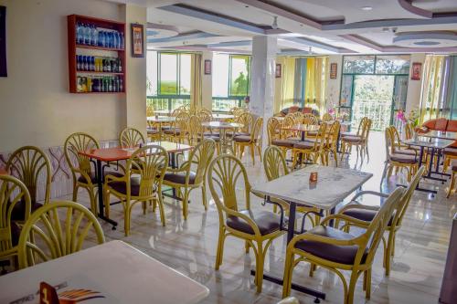 a dining room filled with tables and chairs at The Joy Hotel in Voi