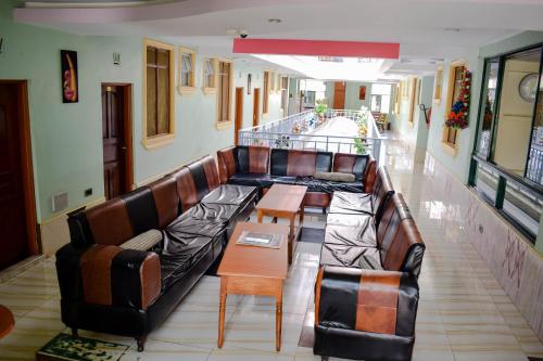 a living room with a long couch and chairs at The Joy Hotel in Voi