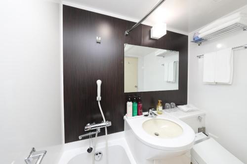 uma casa de banho com um lavatório, um WC e um espelho. em Hotel 21 em Kusatsu