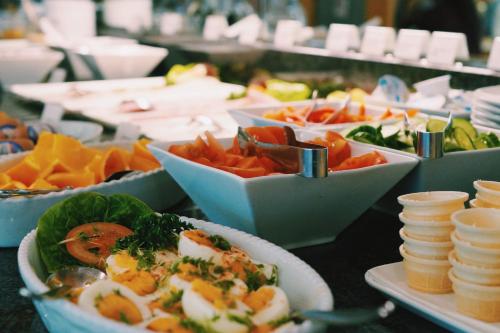 Un buffet con platos de comida en una mesa. en Grand Hostel Berlin Urban, en Berlín