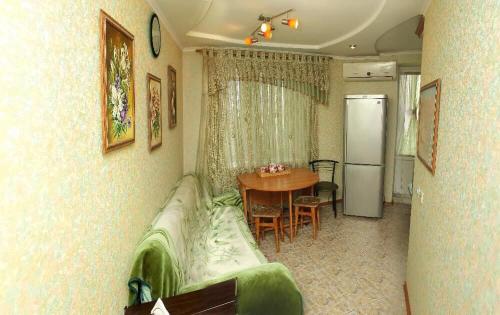 a kitchen with a couch and a table and a refrigerator at Apartment on Shevchenka in Cherkasy
