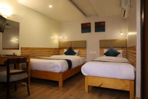 מיטה או מיטות בחדר ב-Nepal Cottage Resort