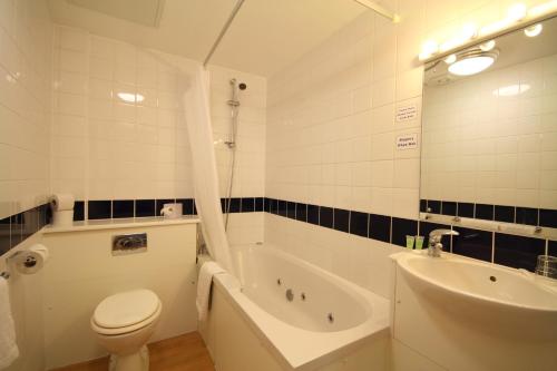uma casa de banho com uma banheira, um WC e um lavatório. em The Grand Scarborough em Scarborough