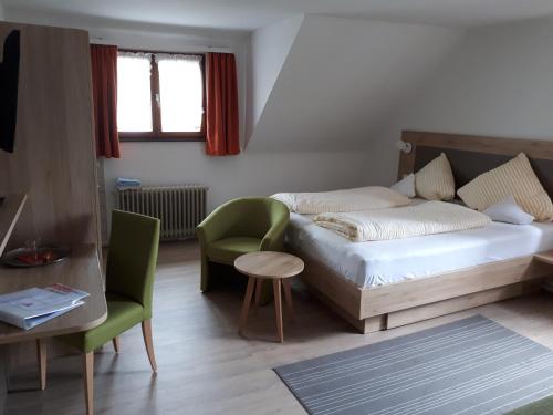 a bedroom with a bed and a chair and a table at Gasthof zur Traube in Konstanz