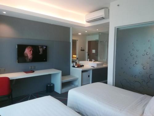 a bedroom with a bed and a bathroom with a sink at Amerin Hotel Johor Bahru in Johor Bahru