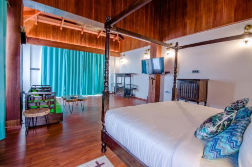 1 dormitorio con 1 cama y sala de estar en Symphony Summer Sands Beach Resort And Spa, en Neil Island