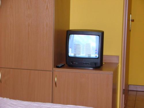 a small television sitting on top of a dresser at Dom Gościnny Pod Brzozami in Poznań