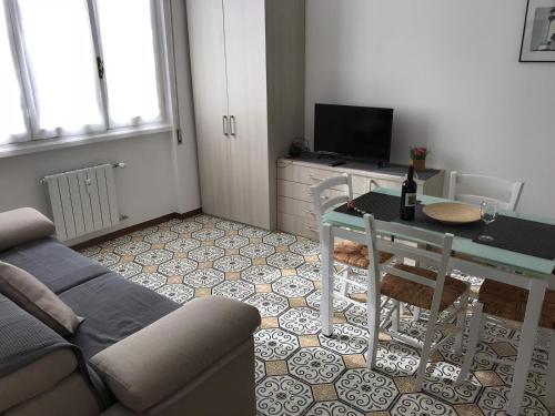 a living room with a couch and a table and a television at Casa gli Scogli in Chiavari