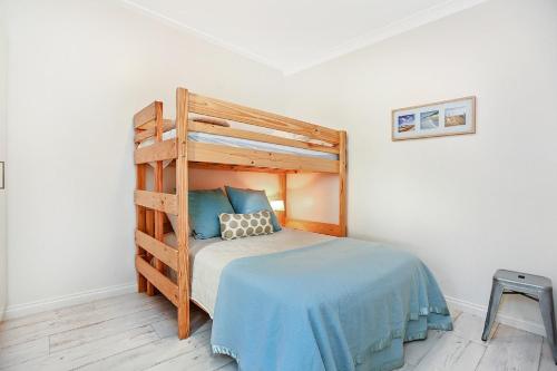 1 dormitorio con litera de madera y sábanas azules en Smugglers Resort-Style Apartments no 9, en Victor Harbor