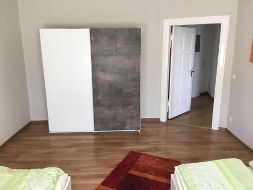 een kamer met een spiegel en een slaapkamer met een hardhouten vloer bij Ferienwohnung Sandow in Cottbus