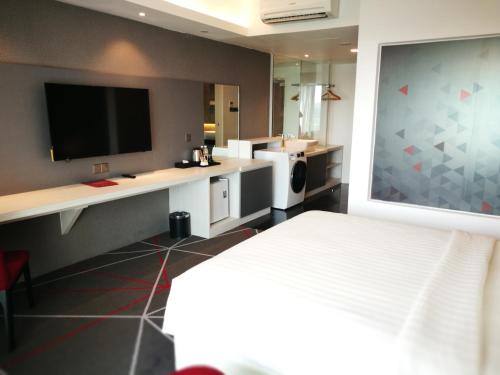 a hotel room with a bed and a flat screen tv at Amerin Hotel Johor Bahru in Johor Bahru