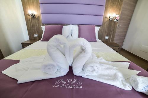 a bed with towels in the shape of a heart at La Palazzina Bed & Breakfast in Porto Cesareo