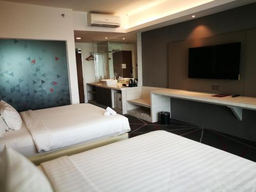 a hotel room with two beds and a flat screen tv at Amerin Hotel Johor Bahru in Johor Bahru
