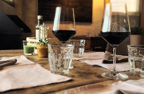 a table with two glasses of red wine on it at Hotel San Francesco in Borgomanero