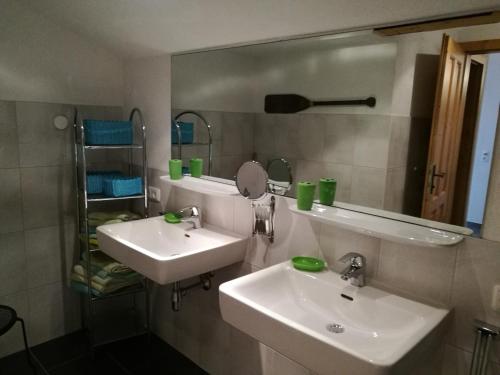 een badkamer met 2 wastafels en een spiegel bij Mosenbauer Ferienwohnung Salzburg in Mittersill