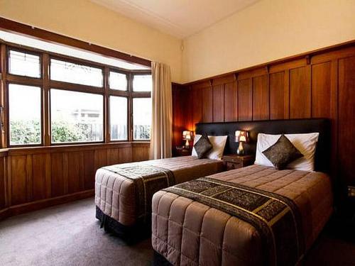 クライストチャーチにあるClarence Cottageのベッド2台と窓が備わるホテルルームです。