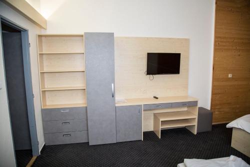 a room with a desk and a tv on a wall at Hotel Červenohorské sedlo in Loučná nad Desnou