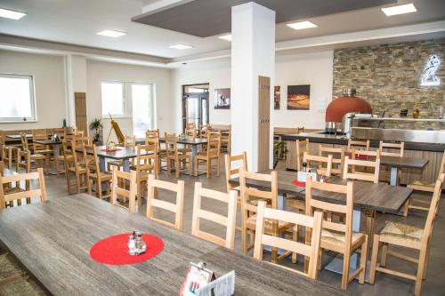 an empty restaurant with wooden tables and chairs at Hotel Červenohorské sedlo in Loučná nad Desnou