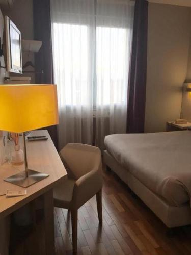 a bedroom with a bed and a desk with a lamp at Hotel San Francesco in Borgomanero