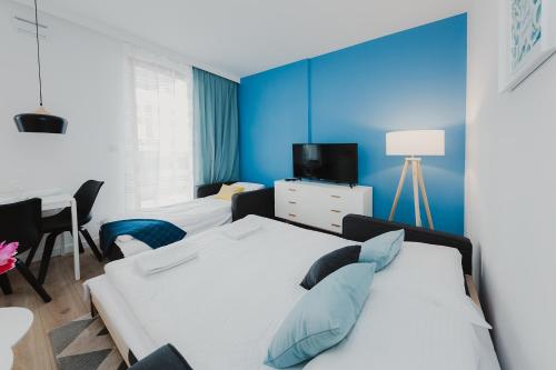 sypialnia z 2 łóżkami i niebieską ścianą w obiekcie ShortStayPoland Kasprzaka (B56) w Warszawie