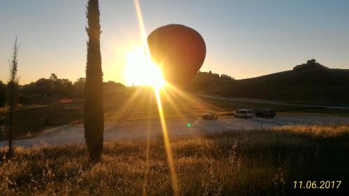 a sun setting over a road with cars in a parking lot at Il Pozzo Della Citerna in Castelnuovo Berardenga