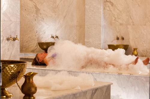 Charmillion Club Resort في شرم الشيخ: الشخص في حوض استحمام مملوء بالرغوة