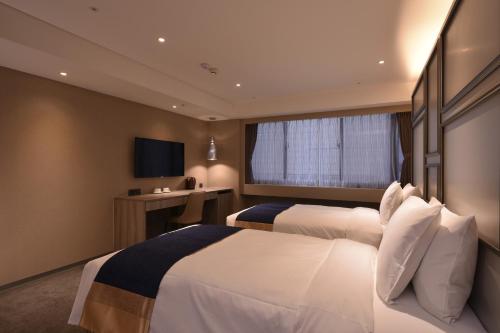 a hotel room with two beds and a television at Green World ZhongXiao in Taipei