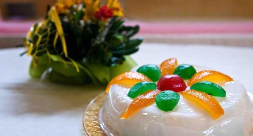 a piece of cake with candy on a plate with a bouquet of flowers at L’altra Sicilia…da Amare in Acquedolci