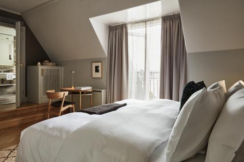 a bedroom with a large bed with white pillows at Hotel St. George Helsinki in Helsinki