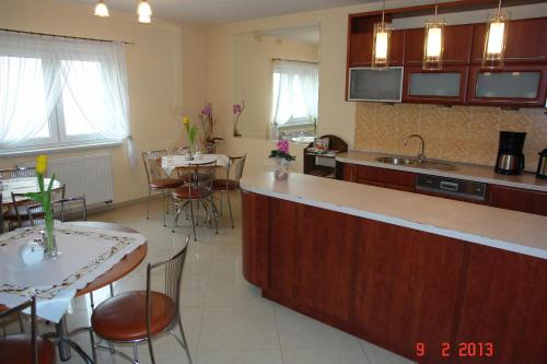 a kitchen with a counter and some tables and chairs at Pokoje Hotelowe Wiktoria in Goczałkowice Dolne